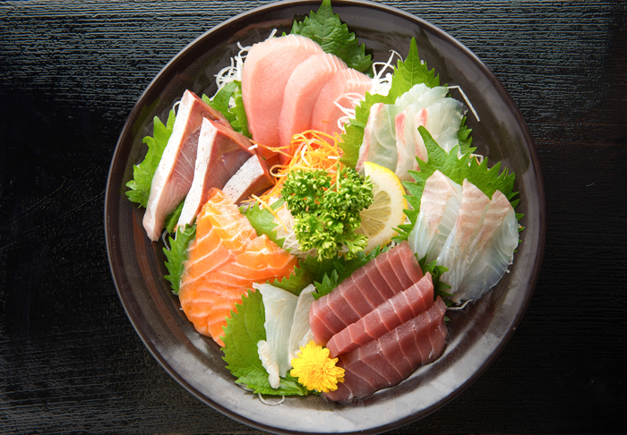 A bowl of sashimi on top of a Japanese salad to match with Giesen Estate Riesling Blush